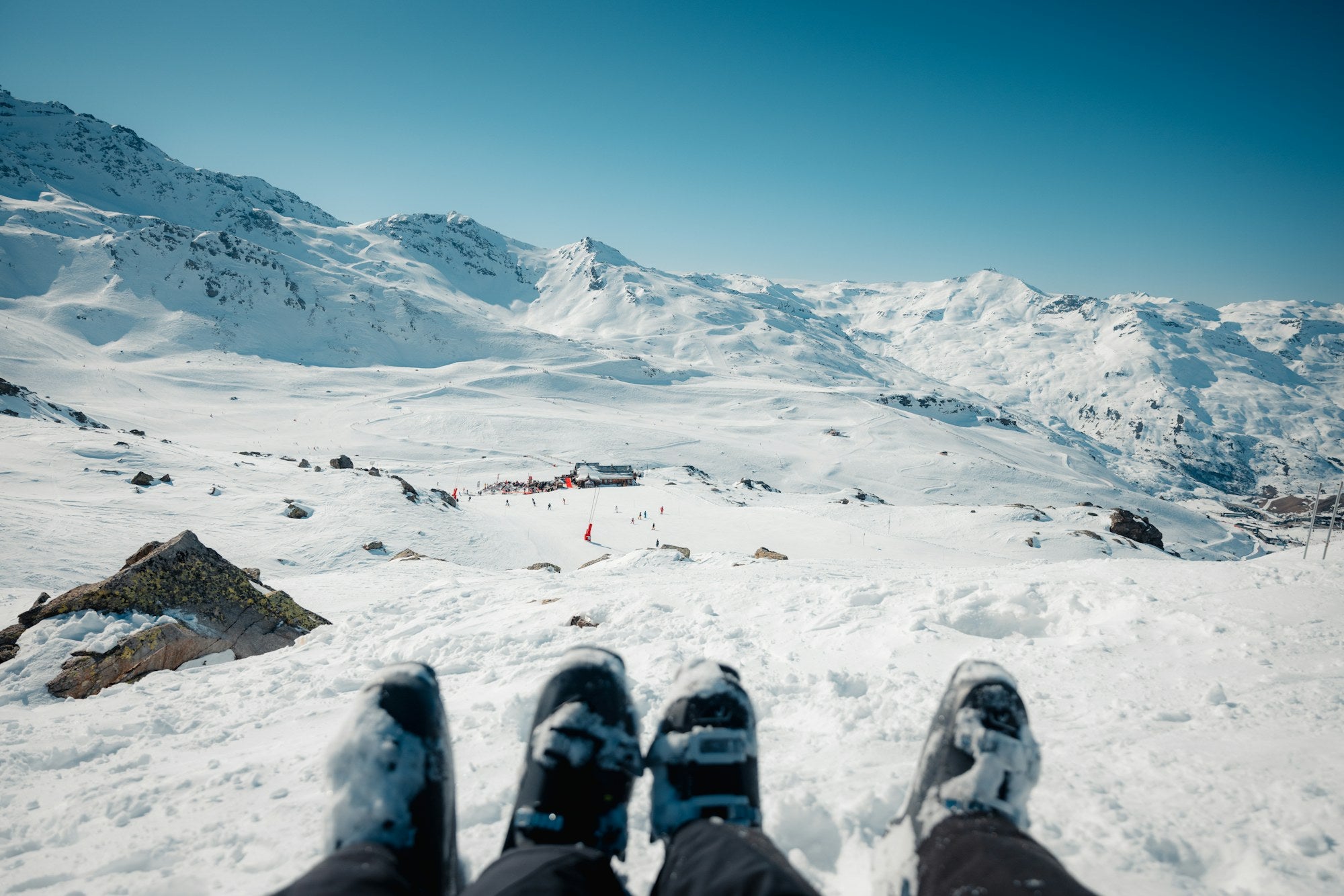 Skiers resting above a snow-covered Alpine mountain landscape